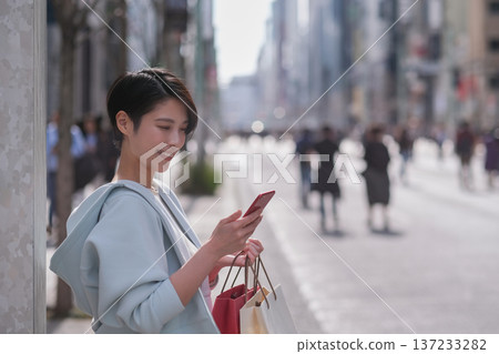 一名女子在銀座街頭看著她的智慧型手機。 137233282