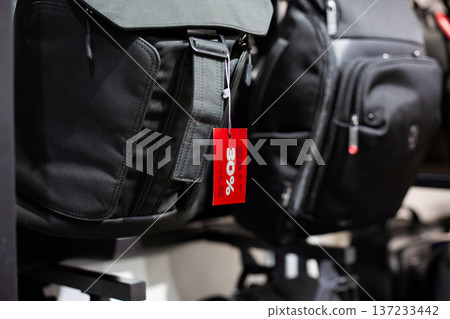 30 percent off sticker on black backpack. Grab backpack during sale. Items are marked down. Get great deal from store while you shopping. Red sign about discount on item in accessories store 30 percent off sticker on black backpack. Grab backpack during sale. Items are marked down. Get great deal from store while you shopping. Red sign about discount on item in accessories store 137233442
