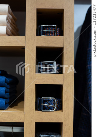 Selection of belts on shelf to complement any classic suit. Find perfect accessory to hold your trousers in place. Premium belts in variety of designs to best match your business suit 137233477