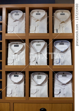 Closet full of classic shirts on display at store features white collared shirts in various shades of white. Cloud Dancer white and other modern white shades. Choose your white color for clothing Closet full of classic shirts on display at store features white collared shirts in various shades of white. Cloud Dancer white and other modern white shades. Choose your white color for clothing 137233480