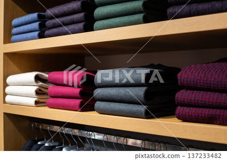 Warm sweaters for staying warm in office in cold weather. Clothing for unheated office. Solution for offices where workers are freezing. Warm classic clothing for men on shelves of business store Warm sweaters for staying warm in office in cold weather. Clothing for unheated office. Solution for offices where workers are freezing. Warm classic clothing for men on shelves of business store 137233482