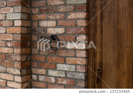 Antique doorknocker at entrance to tavern. Medieval entrance to warm building for warmth and shelter. Vintage design element popular in Middle Ages. Outdated architectural detail Antique doorknocker at entrance to tavern. Medieval entrance to warm building for warmth and shelter. Vintage design element popular in Middle Ages. Outdated architectural detail 137233485