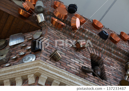 Kitchen utensils in brick wall of old building after being hit by catapult. Medieval war and aftermath of building being destroyed by throwing everything at it. Damaged building, abstract concept 137233487
