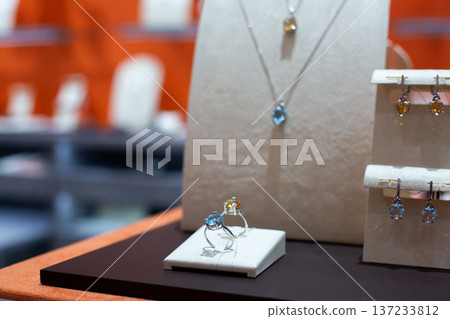 Set of two rings with pendant and earrings in the background. Jewelry set on display in store. Jewelry store with exclusive items for elegance and adornment for girls. Girls love diamonds Set of two rings with pendant and earrings in the background. Jewelry set on display in store. Jewelry store with exclusive items for elegance and adornment for girls. Girls love diamonds 137233812