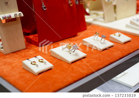 Rings for try on at jewelry store display. Determining your finger size to buy right ring. Importance of knowing ring diameter before purchasing. Demonstration rings with gemstones for try on Rings for try on at jewelry store display. Determining your finger size to buy right ring. Importance of knowing ring diameter before purchasing. Demonstration rings with gemstones for try on 137233819