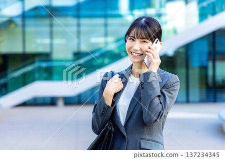 Business woman speaking on a smartphone Business woman speaking on a smartphone 137234345