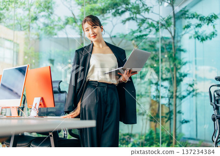 Foreign woman working on a computer in the office 137234384