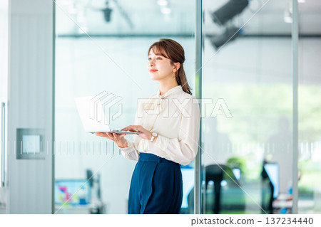 在辦公室使用筆記型電腦的年輕女商人 137234440