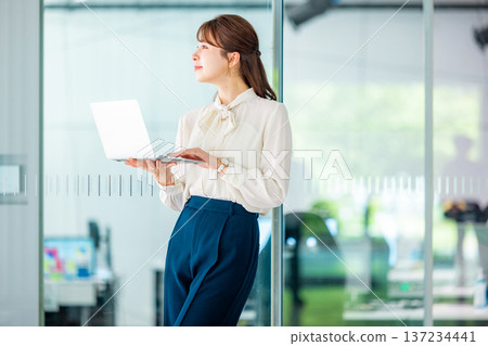 在辦公室使用筆記型電腦的年輕女商人 137234441