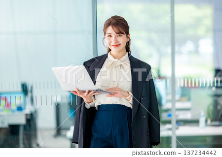 在辦公室使用筆記型電腦的年輕女商人 137234442