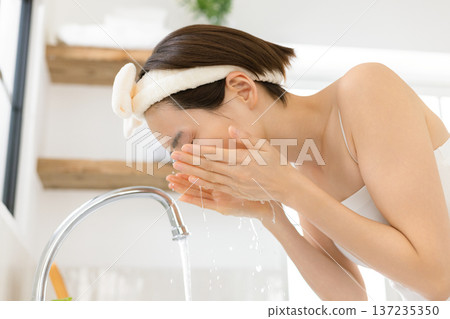Beauty: A woman washing her face in the bathroom Beauty: A woman washing her face in the bathroom 137235350