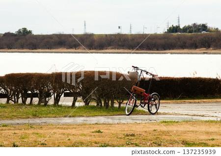 一輛紅色迷你自行車和渡良瀨水庫岸邊蕭瑟的冬日景色 137235939