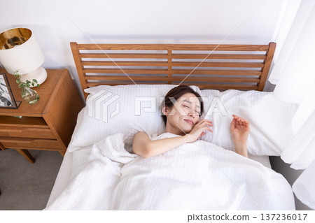 從空中俯瞰，一位女子在床上熟睡。 137236017