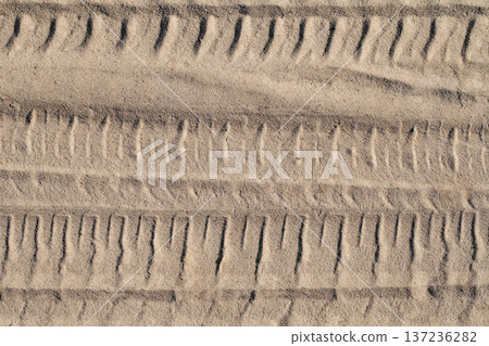 Footprint of a car wheel in the sand close-up 137236282