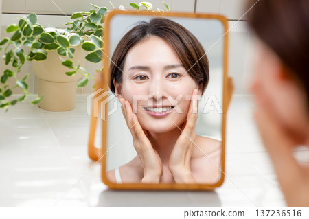 Beauty: A woman doing skin care in the bathroom 137236516