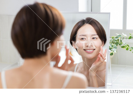 Beauty: A woman doing skin care in the bathroom 137236517