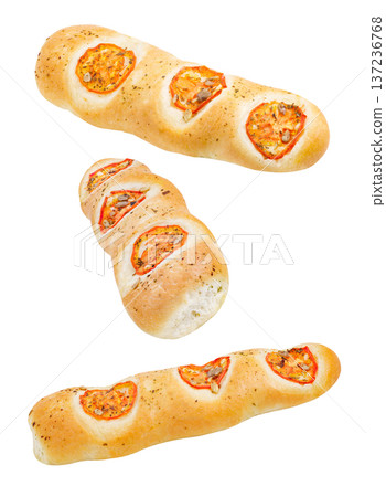Baguettes with dried tomatoes falling, hanging, flying, soaring isolated on white background Baguettes with dried tomatoes falling, hanging, flying, soaring isolated on white background 137236768