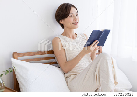 Well-being: A woman reading in bed 137236825