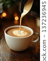 Barista Pouring Cream into Coffee with Latte Art in a White Cup 137236945