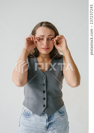 Title: Crying Woman Rubbing Eyes in Studio Title: Crying Woman Rubbing Eyes in Studio 137237245