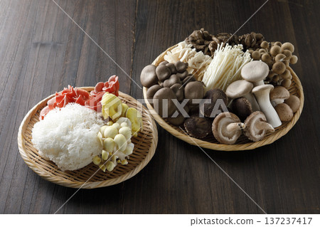 Various types of mushrooms in a colander on a wood grain background 137237417