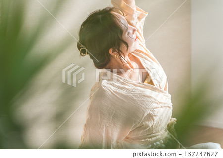 A woman doing yoga in the living room at home (relaxation, health care) A woman doing yoga in the living room at home (relaxation, health care) 137237627