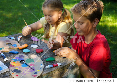 Young hands turn simple stones into miniature masterpieces, sharing their creativity through heartfelt homemade presents. 137238001