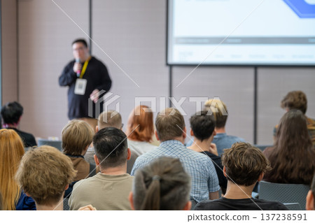 Business conference speaker presenting to audience in a bright modern conference room 137238591