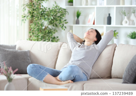 Asian woman relaxing and resting sitting in a comfortable sofa Asian woman relaxing and resting sitting in a comfortable sofa 137239489