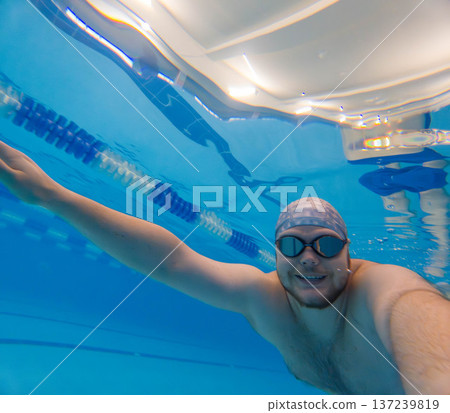 Underwater selfie of swimmer in blue pool with goggles 137239819