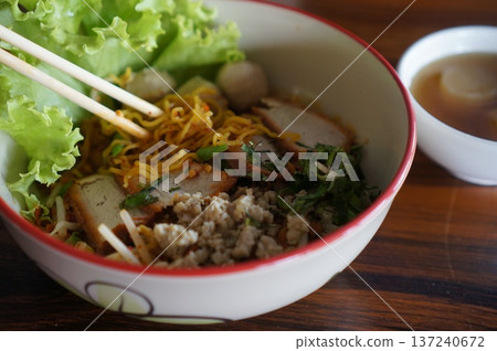 Traditional Sukhothai Tom Yum Rice Noodles with Sliced Long Beans, Red Pork, and Soft-Boiled Egg 137240672