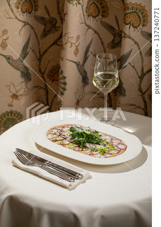 Octopus carpaccio with arugula and parmesan Octopus carpaccio with arugula and parmesan 137240771