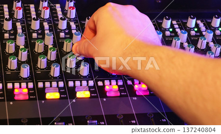 Hand Moves Control Knob On Mixer,, Sound Engineer Controls Levels. Audio Production, Studio Technology, Creative Workflow. 137240804