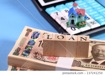 Image of a mortgage loan with a stack of new 10,000 yen bills, a miniature house, a calculator, and LOAN blocks (light blue background) Image of a mortgage loan with a stack of new 10,000 yen bills, a miniature house, a calculator, and LOAN blocks (light blue background) 137241250