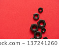 Hexagonal bolt and nut on a red background 137241260