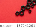 Hexagonal bolt and nut on a red background 137241261