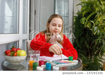 Smiling young girl painting. Child and colorful paints and kitten at home. Childhood, 137241330