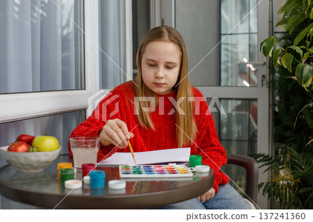 Portrait of child drawing pink cats in a sketchbook. Young preteen girl painting Portrait of child drawing pink cats in a sketchbook. Young preteen girl painting 137241360