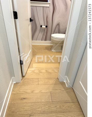 Light blue wall paneling with a wall outlet and natural wood flooring, showcasing clean finishing and detail work. Ideal for home improvement or interior design. 137241573