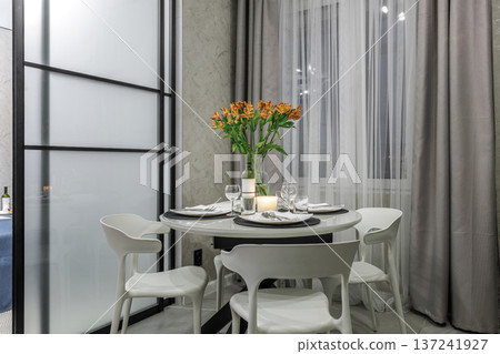 Dining Area with Flowers and Table Setting in Modern Studio Dining Area with Flowers and Table Setting in Modern Studio 137241927