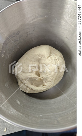 Raw dough ball in metal bowl ready for baking process. Homemade cooking preparation symbolizing bread making, fermentation and kitchen activity concept 137242444
