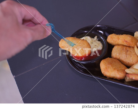 Hand Dipping Crispy Chicken Nugget into Tomato Ketchup Hand Dipping Crispy Chicken Nugget into Tomato Ketchup 137242874