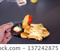 Hand Dipping Crispy Chicken Nugget into Tomato Ketchup 137242875