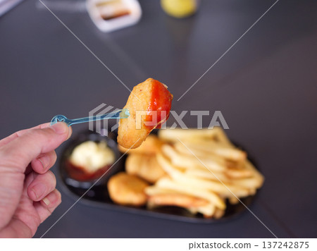 Hand Dipping Crispy Chicken Nugget into Tomato Ketchup Hand Dipping Crispy Chicken Nugget into Tomato Ketchup 137242875