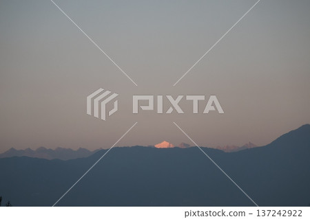 View of the evening sky and the glittering snow-capped peaks of the Himalayas and the silhouettes of nearby mountains from the rooftop of a hotel in Kathmandu View of the evening sky and the glittering snow-capped peaks of the Himalayas and the silhouettes of nearby mountains from the rooftop of a hotel in Kathmandu 137242922