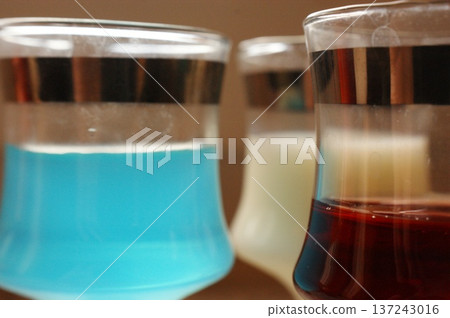 three glasses of colorful alcoholic beverages 137243016