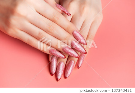 Woman's hands showing long pink almond nails with red tips Woman's hands showing long pink almond nails with red tips 137243451