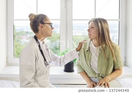 Doctor reassuring patient at clinic visit, supportive consultation and guidance Doctor reassuring patient at clinic visit, supportive consultation and guidance 137244349