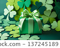 Clover leaves, gift box and beads on green background 137245189