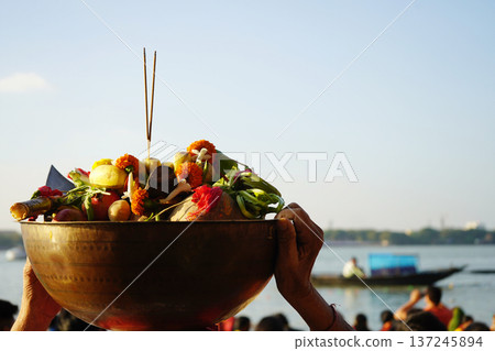 Traditional brass bowl filled with fruits and incense offerings for Chhath Puja festival on the Ganges river 137245894